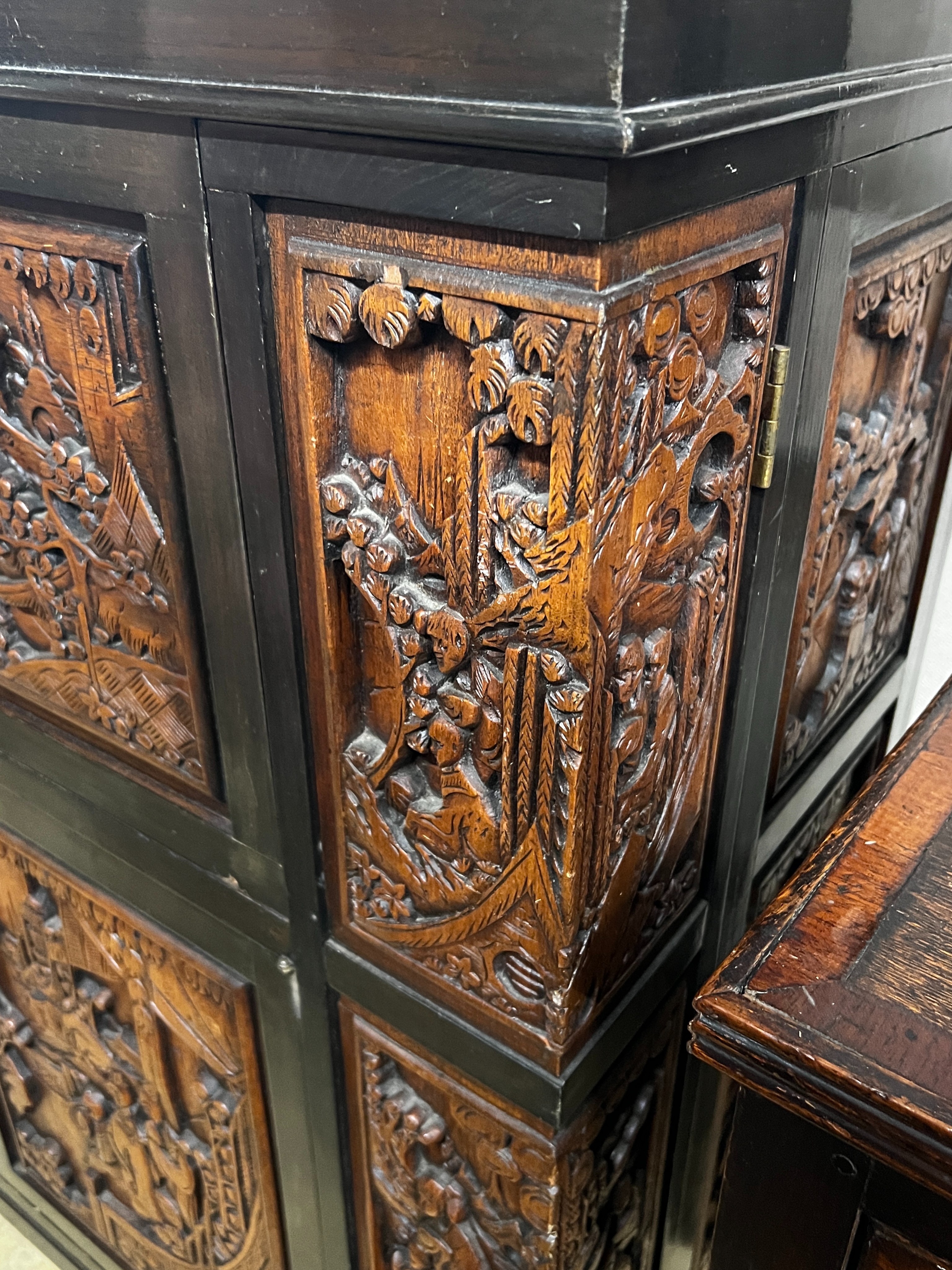 A Chinese carved hinged top cocktail cabinet with mirrored interior, width 111cm, depth 46cm, height 107cm